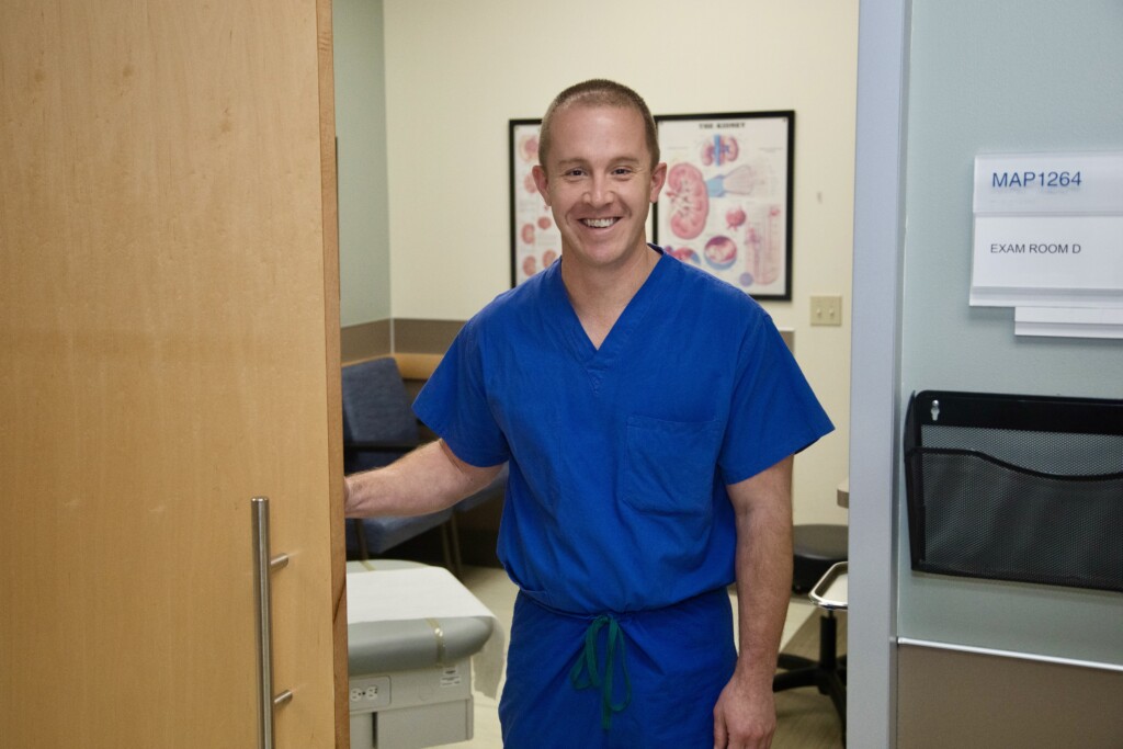 Urologist Dr. Brock Boehm walks into exam room.