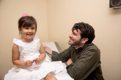 Doctor with young female patient laughing.
