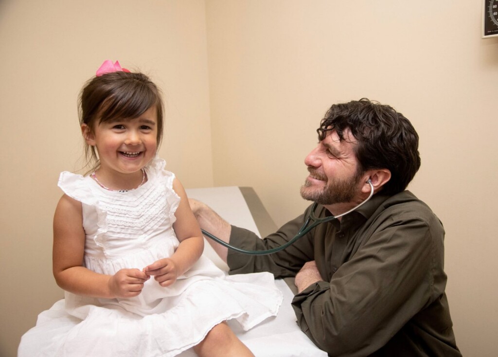 Doctor with young female patient laughing.