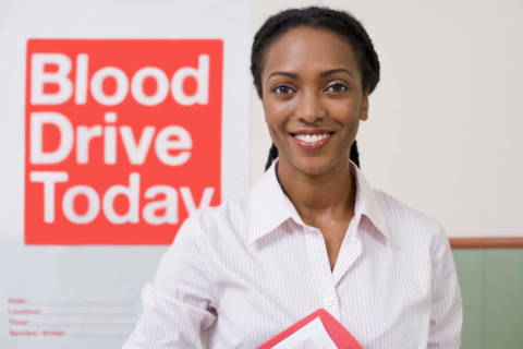 Woman standing in front of blood drive sign.