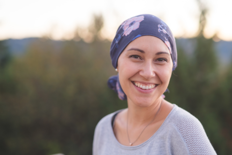Happy woman standing in a field with a head wrap on