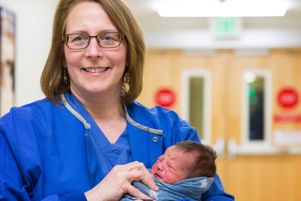 Dr. Garde holds a newborn baby.