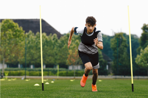 Young male athlete running on a field.