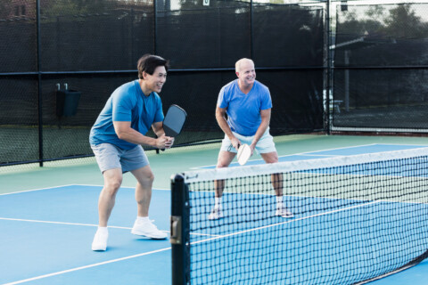 Two males playing pickleball.