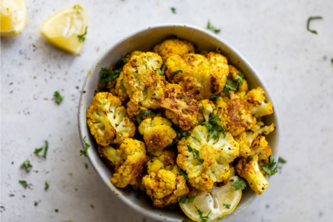 Bowl of roasted cauliflower with curry seasoning and mint