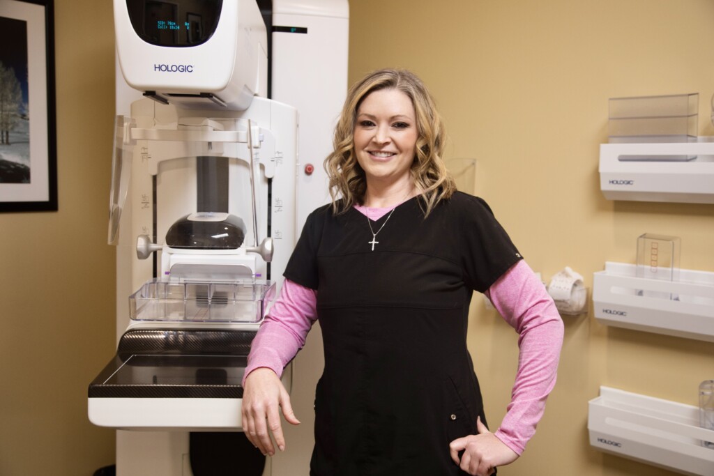 Mammography technologist Nicole Kingsley standing in front of the mammography machine.
