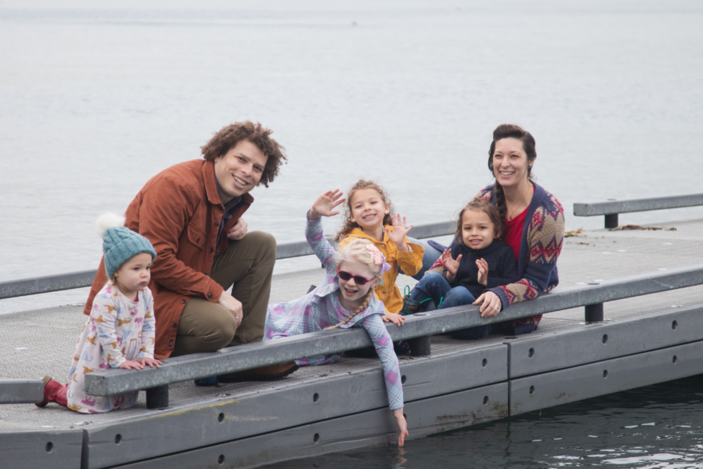 Family Medicine provider Jason Blair, MD with his wife and four children exploring a dock.