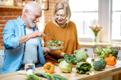 Older man and woman cooking together in the kitchen.