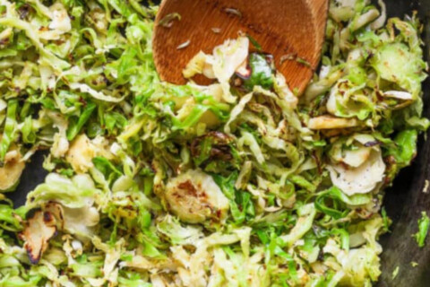 Shredded Brussels sprouts with balsamic vinaigrette in a bowl.