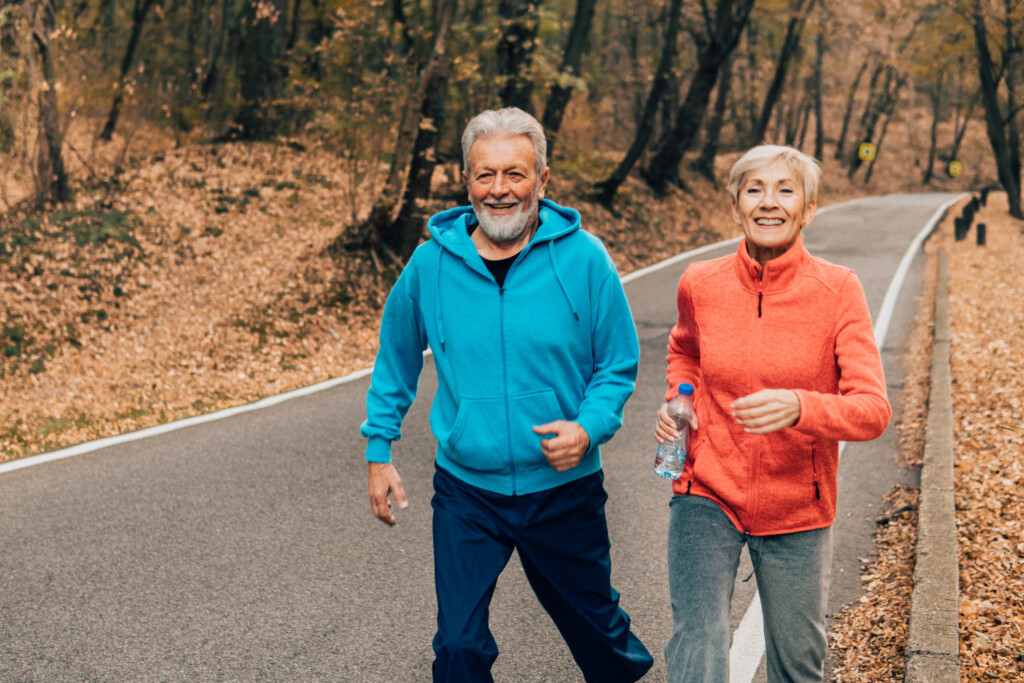 Two older adults running in the fall