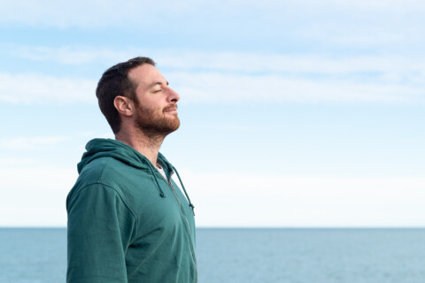 Middle aged man breathing by the sea