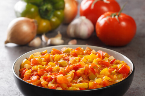 Bowl of spanish softrito with an arrangement of vegetables