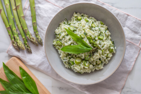 Bowl of asparagus risotto on white table