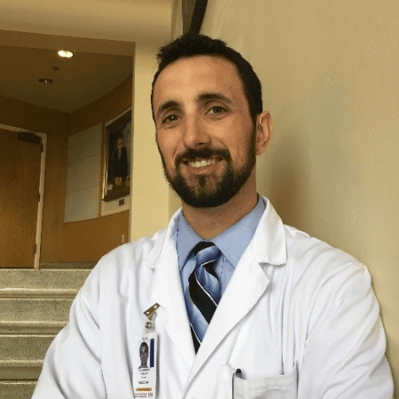 Man leaning against the wall smiling.