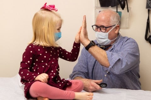 Dr. Richards giving a high five to a young, female patient.